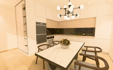 A fitted kitchen with black marble walls and a dining table under a chandelier, in baked light